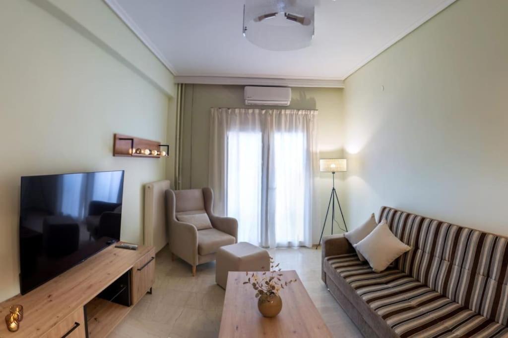 a living room with a couch and a television at Christina's Cozy Apartment Volos in Volos