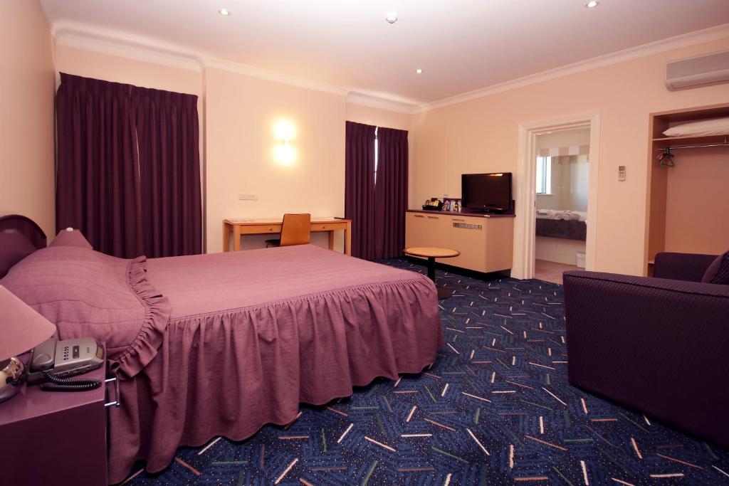 a hotel room with a bed and a television at Mitchell River Tavern in Bairnsdale