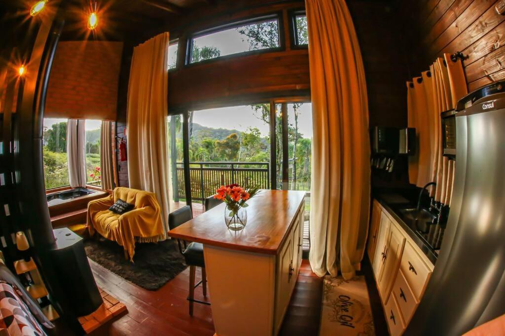 a kitchen with a table with a vase of flowers on it at Cabana Agatha - Alfredo Wagner SC in Barracão