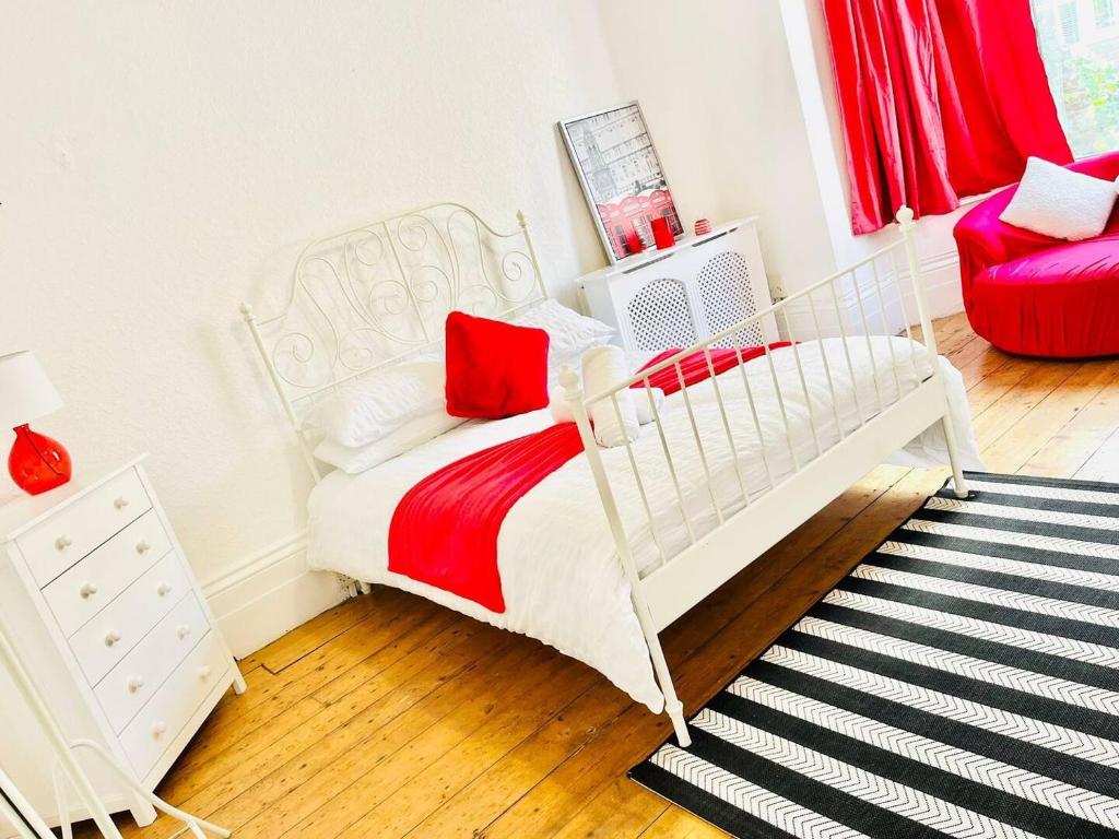 a white bed in a room with a red chair at Taswell House in Portsmouth