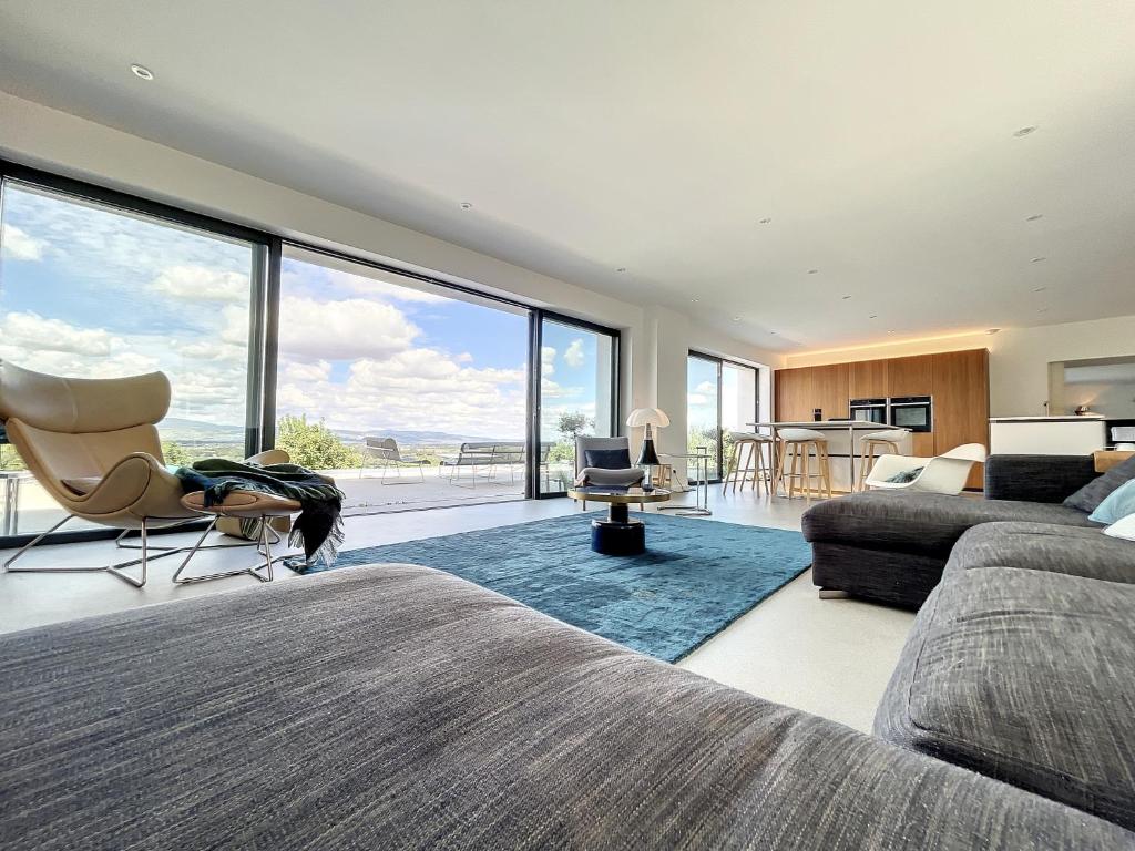 une chambre avec deux lits et une grande fenêtre dans l'établissement Domaine de l'Heure Bleue, à Genouilleux