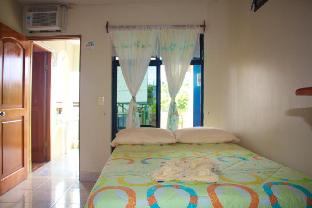 a bed with towels on it in a room with a window at Hostal Nathaly in Puerto Baquerizo Moreno