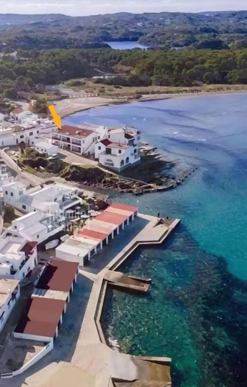 an aerial view of a resort next to the water at Es Grau Lamorino in Es Grau