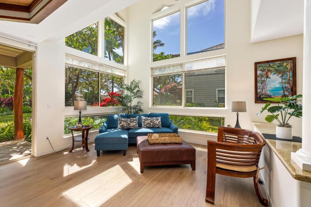 a living room with a blue couch and windows at B4 Palm Villas at Mauna Lani in Waikoloa