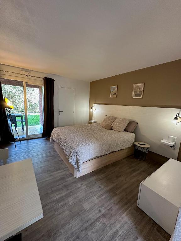 une chambre avec un lit et une grande fenêtre dans l'établissement Nid douillet avec terrasse au calme, à Arles