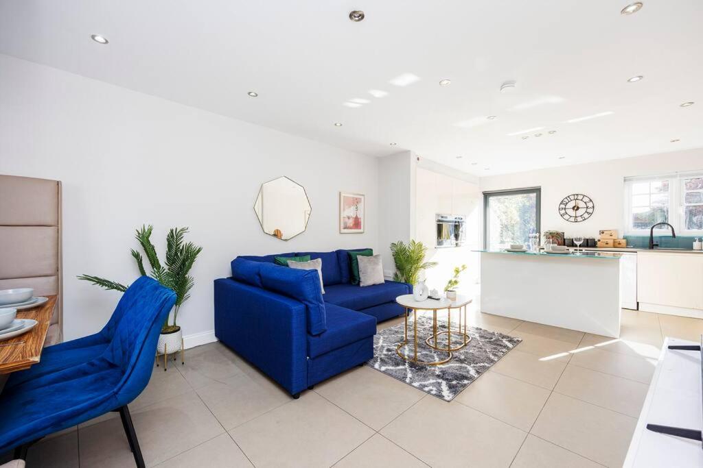 a living room with a blue couch and a table at 4 Bed Townhouse in Uxbridge Ideal For Families or Contractors By AV Stays Short Lets in Hillingdon