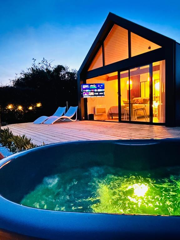a large tub of water in front of a house at Home Paradis & Spa in Souvigné