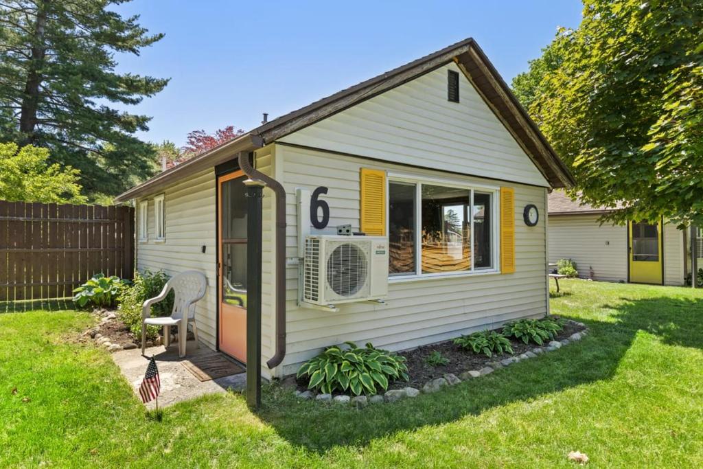 a small white house with a yard at Chippewa Bluffs Resort Spacious Combined 3BR 3BA Cabins in Barryton