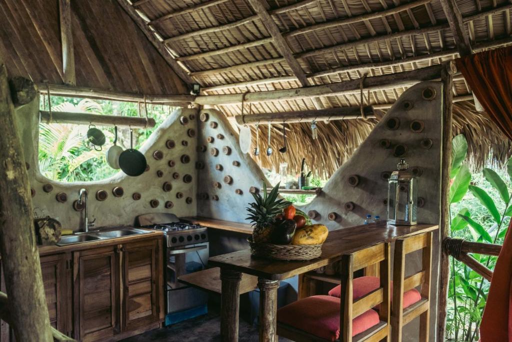 cocina con mesa y fogones en una habitación en Bungalows India, El Valle, Samana, en Santa Bárbara de Samaná