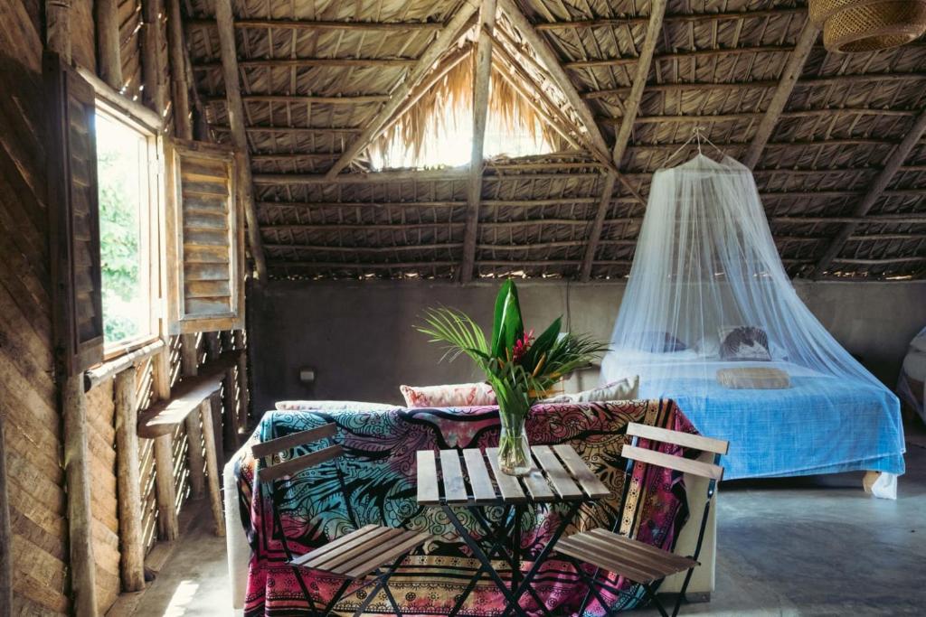 1 dormitorio con 1 cama y 1 hamaca en una habitación en Bungalows India, El Valle, Samana, en Santa Bárbara de Samaná
