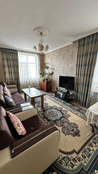 a living room with a couch and a television at Apartment close to the boulevard in Mingachevir