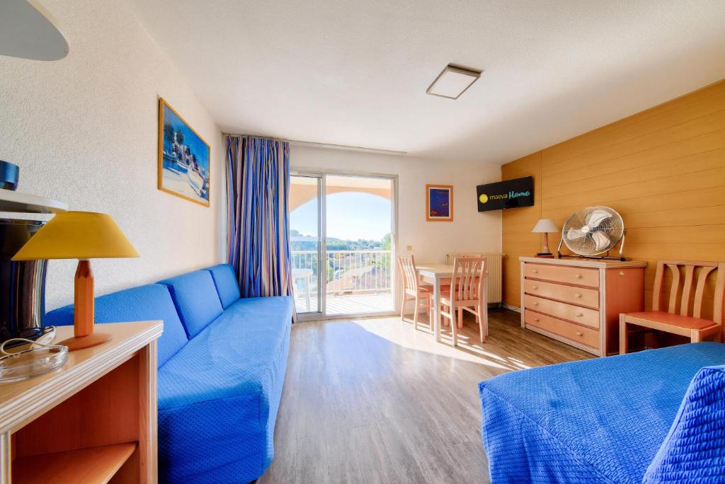 une chambre d'hôtel avec un canapé bleu et une table dans l'établissement Résidence les Hauts de Balaruc - maeva Home - Appartement 2 pièces 4 personnes - Budget MAE-5791, à Balaruc-les-Bains