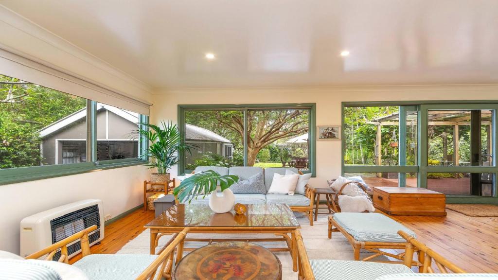 ein Wohnzimmer mit Couch und Kamin in der Unterkunft Kookaburra Cottage Pearl Beach in Pearl Beach