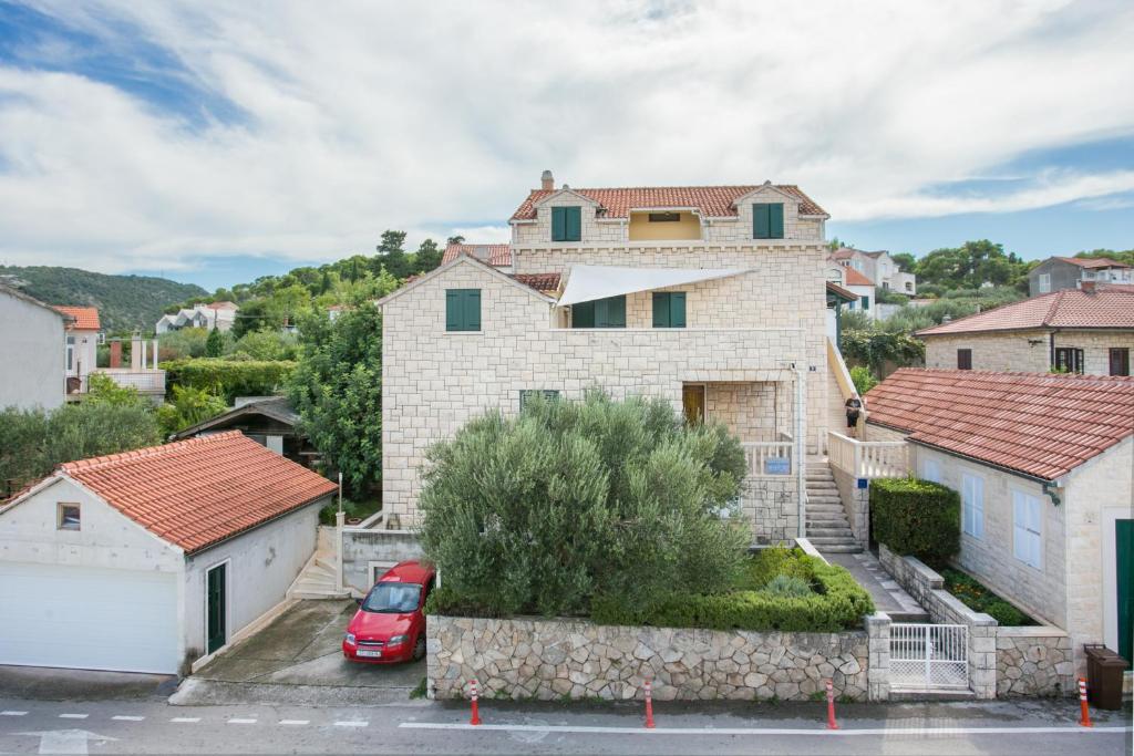 a house with a car parked in a parking lot at Apartments by the sea Postira, Brac - 739 in Postira