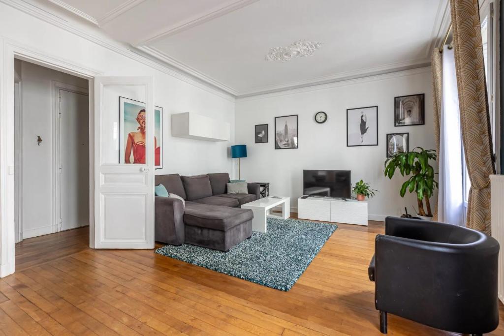 un salon avec un canapé et une télévision dans l'établissement Appartement cozy en plein cœur de Paris, à Paris