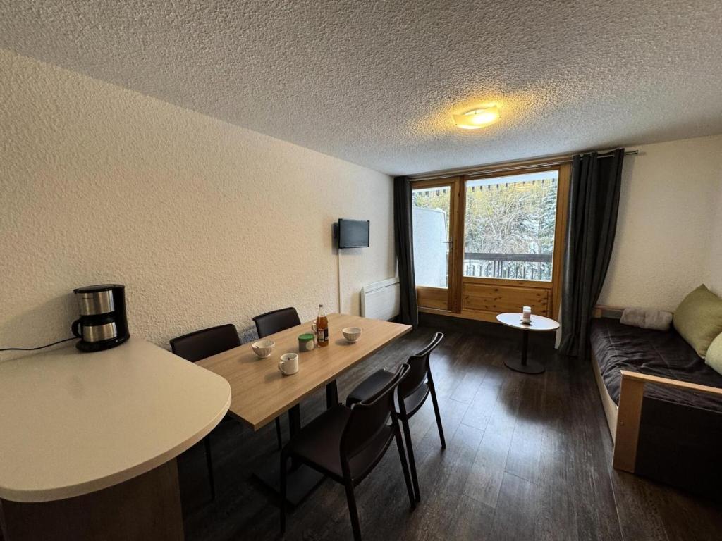 a room with a table and chairs and a couch at Résidence Bois Des Coqs - Studio confortable · Proche des pistes · Coin montagne & parking extérieur MAE-0294 in Champcella