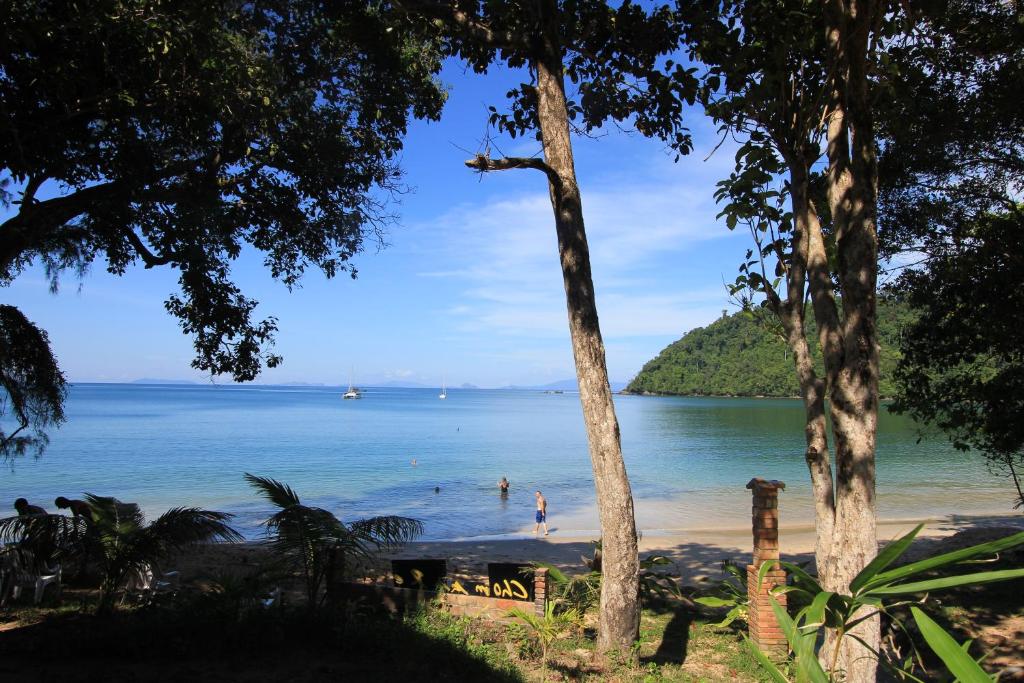 a beach with a group of people swimming in the water at Chomjan Resort in Ko Phayam
