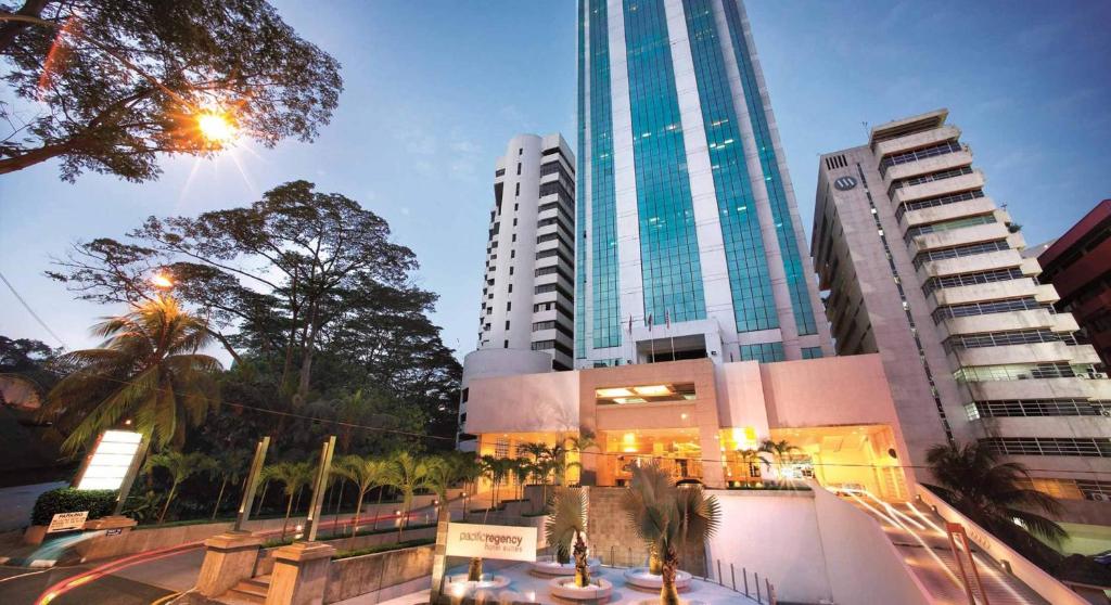 a city street with tall buildings and a clock tower at Pacific Regency Hotel Suites in Kuala Lumpur