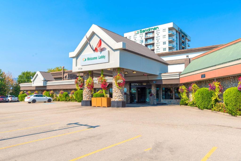 a store front of a building with a parking lot at Sandman Hotel & Suites Kelowna in Kelowna