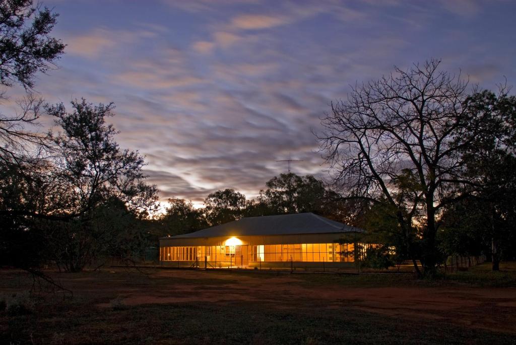 a lit up building at night with a sky at Gundabooka National Park Cottages in East Toorale