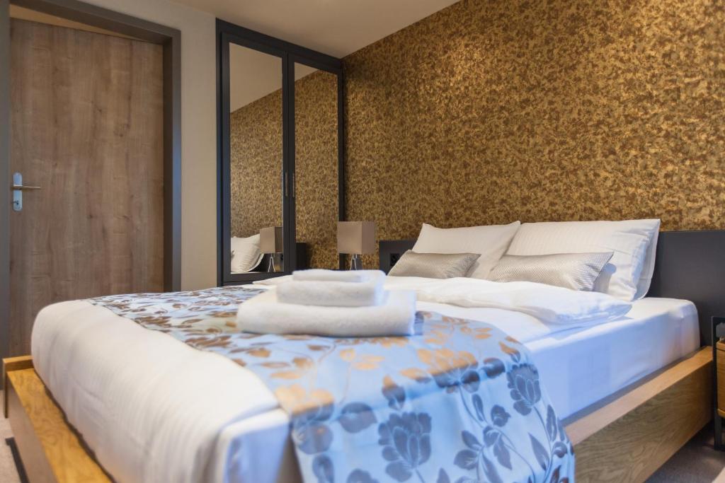 a bedroom with a bed with a blue and white comforter at Plaza Hotel Winterthur in Winterthur