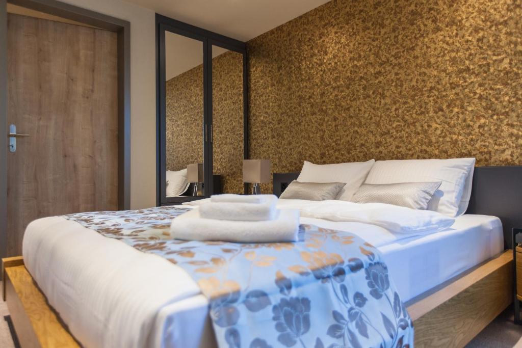 Schlafzimmer mit einem Bett mit einer blauen und weißen Bettdecke in der Unterkunft Plaza Hotel Winterthur in Winterthur