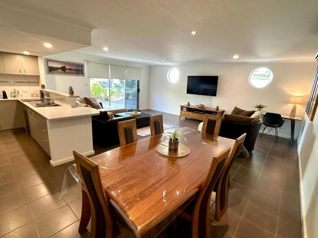 a kitchen and a living room with a wooden table at SeventyThree at Cape View Resort in Broadwater