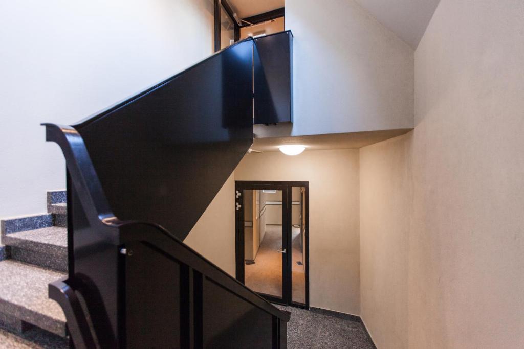 a staircase with a black rail and a stair case at Plaza Hotel Winterthur in Winterthur