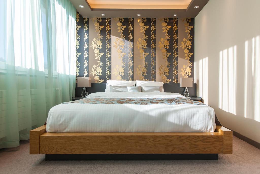 a bedroom with a large bed and some windows at Plaza Hotel Winterthur in Winterthur