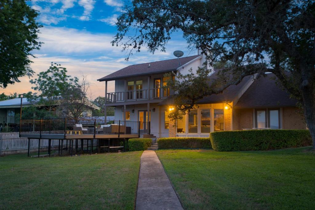 a large house with a lawn in front of it at Travis by AvantStay Waterfront Lake Retreat in Lakeway