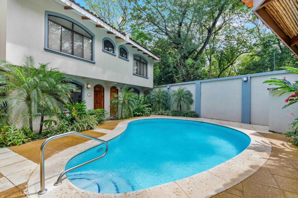 a swimming pool in front of a house at Pool Oasis, Concierge & 5min drive to the Beach in Playa Flamingo