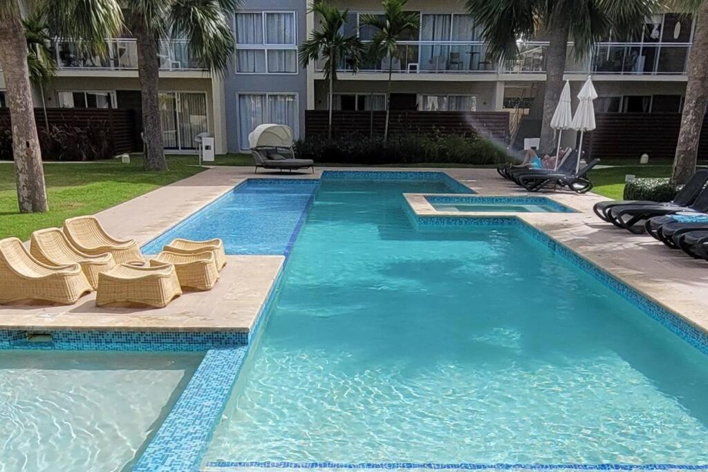 a swimming pool with lounge chairs and a building at Vibe Gorgeous one bedroom apartment view beach in La Laguna
