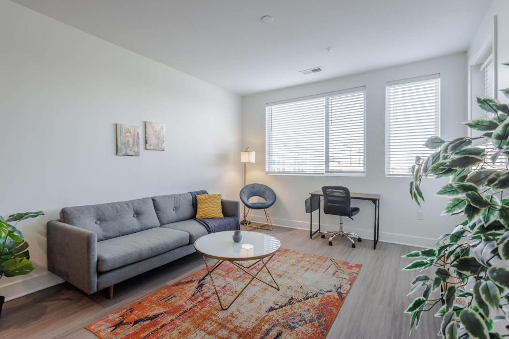 TWO Luxe CozySuites in Downtown Cincinnati في سينسيناتي: غرفة معيشة بها أريكة وطاولة