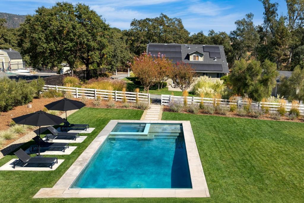 una piscina in un cortile con sedie e ombrelloni di Wine Country Estate by AvantStay Pool Spa Barn a Sonoma
