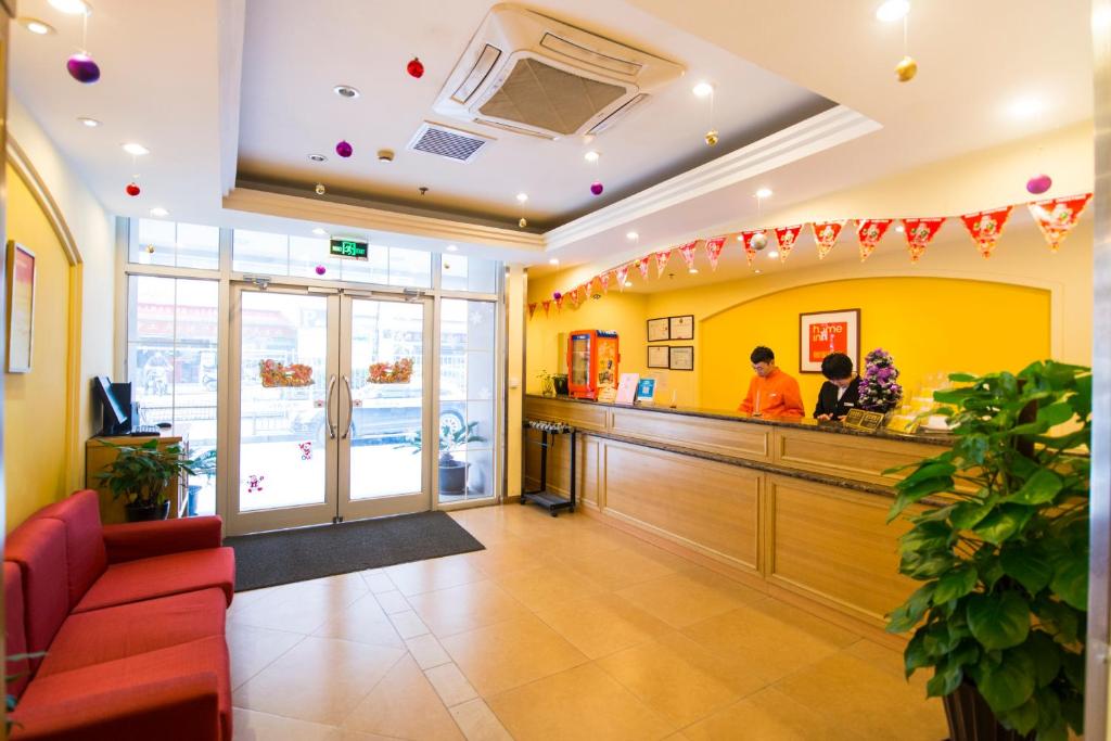 un restaurant avec un comptoir et des personnes debout au comptoir dans l'établissement Home Inn Changchun Quan'an Square Airport Shuttle, à Changchun