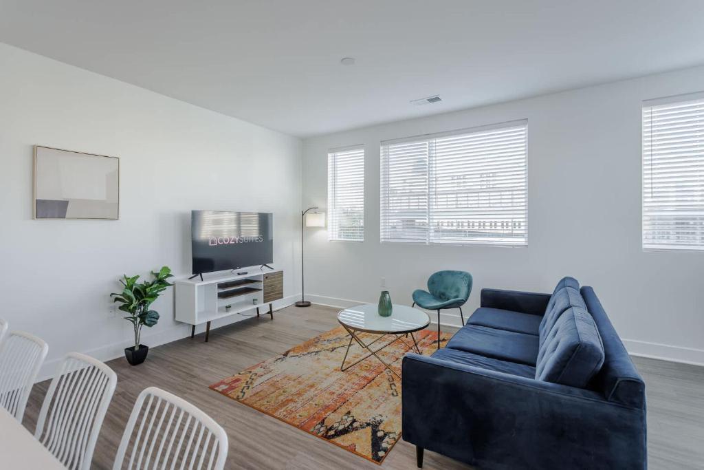 a living room with a blue couch and a tv at Cozysuites l Luxe 2BR in Downtown Cincinnati #5 in Cincinnati