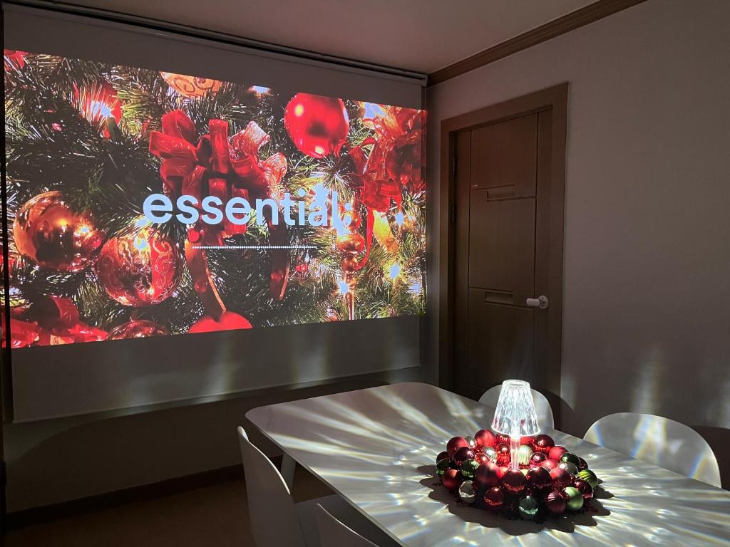 a dining room with a table and a large screen at Busan Vacance Stay, cozy house in Busan