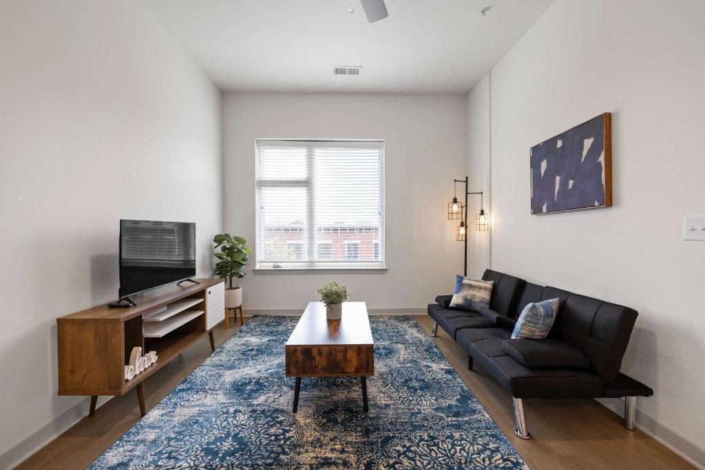 a living room with a couch and a table at Stunning Nulu 1BR CozySuites 07 in Louisville