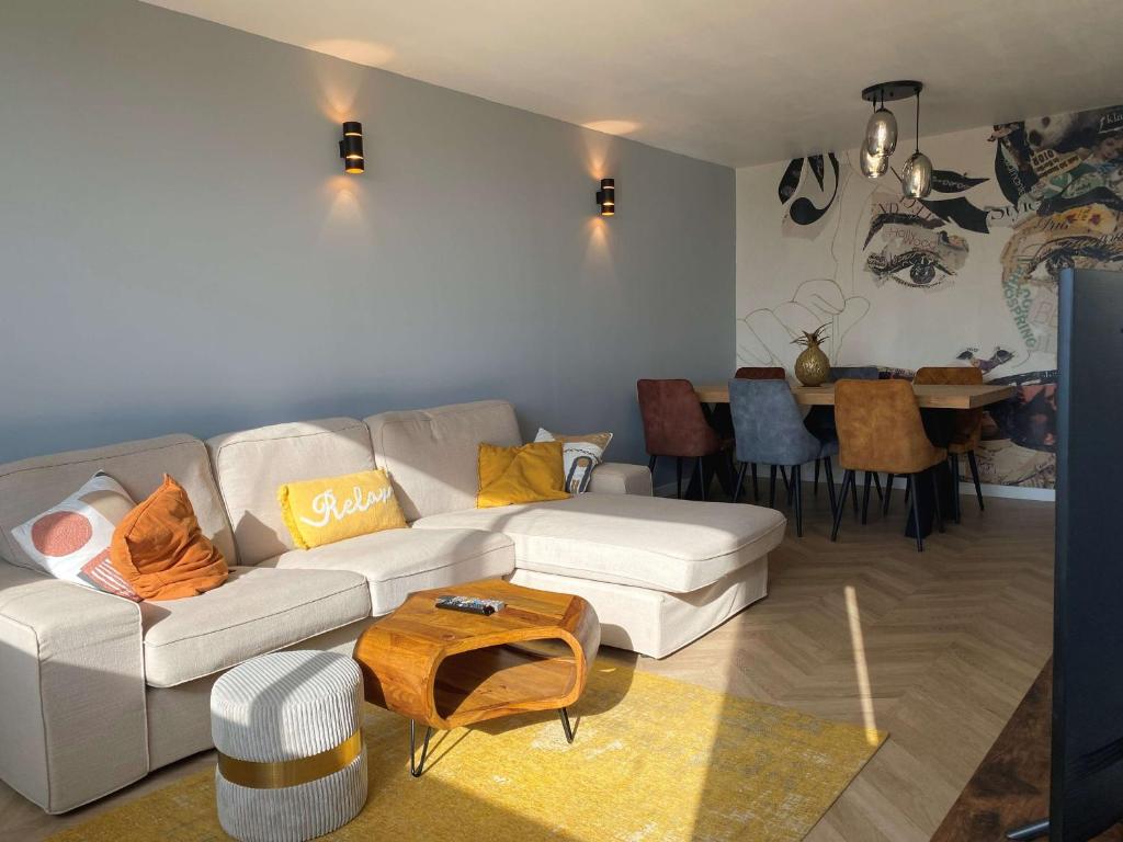 un salon avec un canapé blanc et une table dans l'établissement Spacieux T2, dernier étage, confort moderne, Wi-Fi, Balaruc-les-Bains - FR-1-553-276, à Balaruc-les-Bains