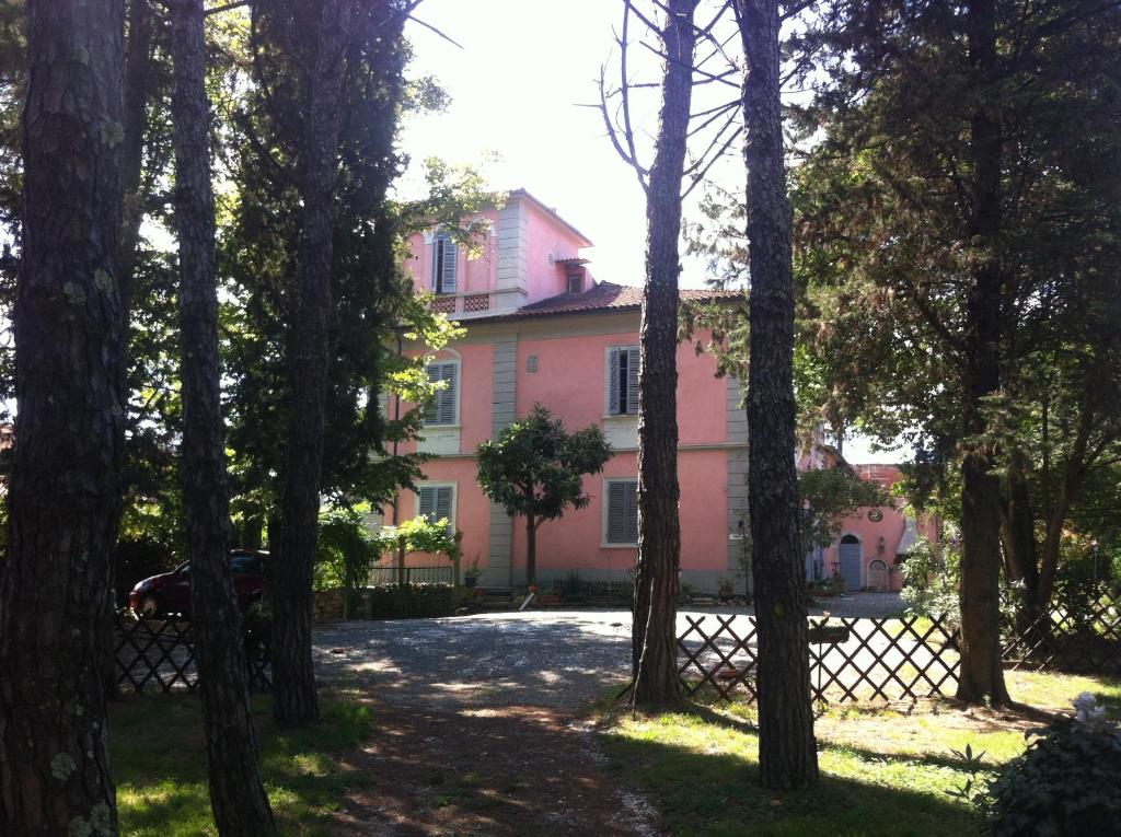 a pink house through a bunch of trees at Villa Arianna B&B in Lari