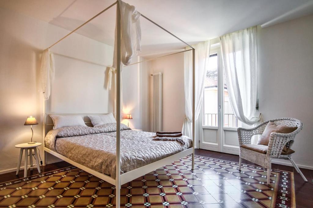 a bedroom with a four poster bed and a window at Regina 24 in Cernobbio