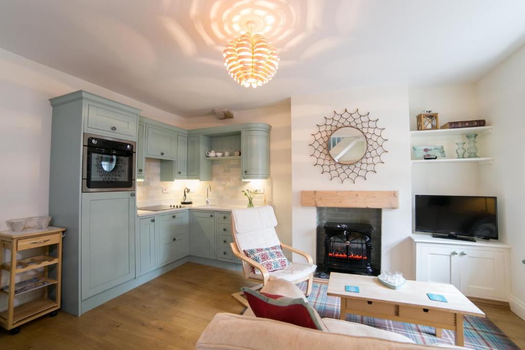 a kitchen with blue cabinets and a living room at Milburn Cottage in Bellingham