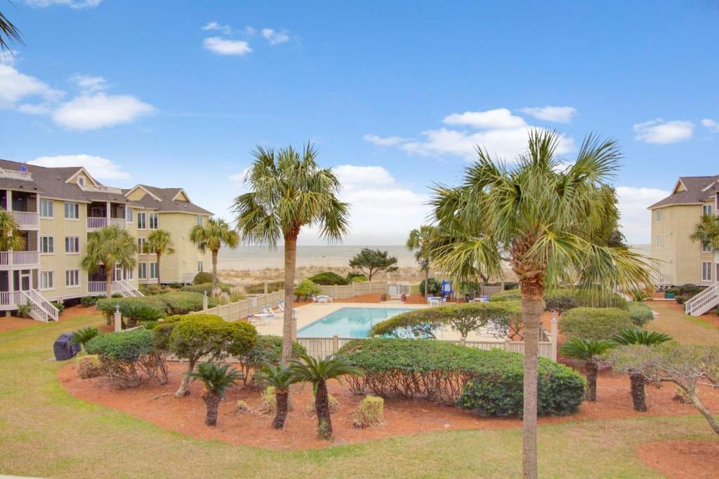 an aerial view of a resort with a pool and palm trees at 202 D Port O Call by AvantStay Beach Condo in Isle of Palms