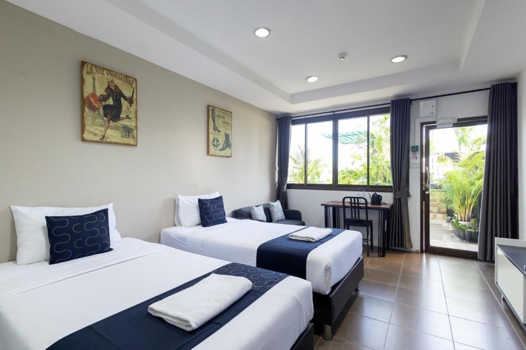 a hotel room with two beds and a balcony at Nature Boutique Residence in Bangkok