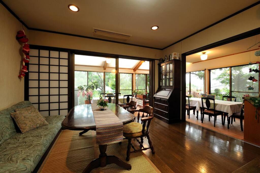 a living room with a table and a dining room at 山魚亭 in Izunokuni