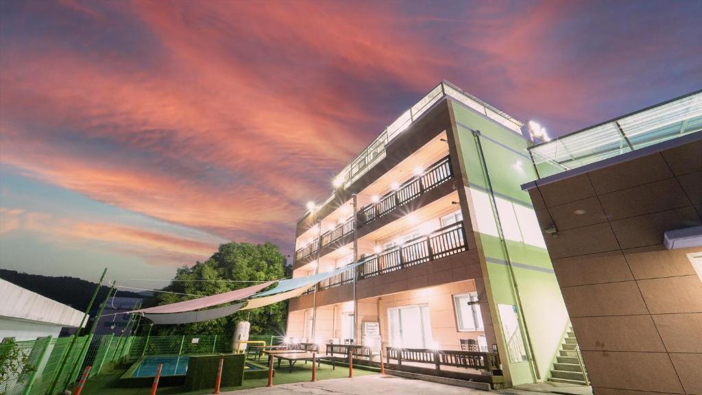 a building with a cloudy sky above it at yeosu moranggee pension in Yeosu