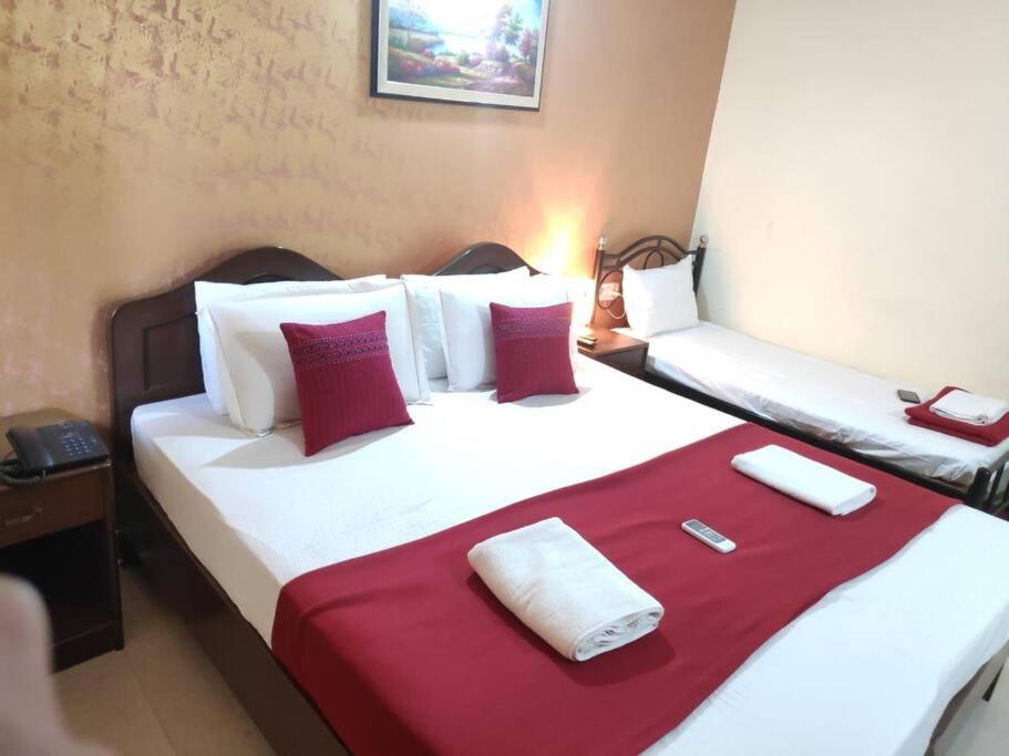 a bedroom with a large bed with red and white pillows at Baga Beach Homestay near Tito`s lane in Baga