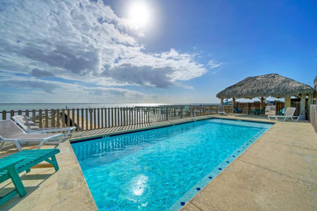 a swimming pool with a view of the ocean at 6BDR Balcony w Bay View Shared Pool Boat Dock Keeper Red by AvantStay in Padre Island