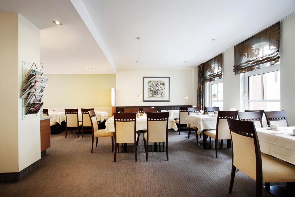 a dining room with white tables and chairs at Hotel am Jakobsmarkt in Nuremberg