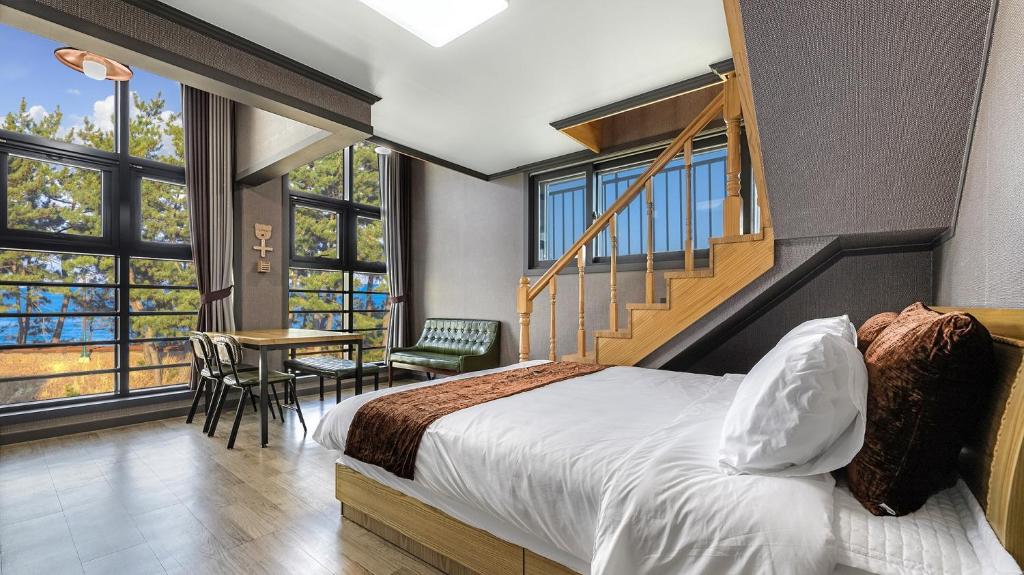 a hotel room with a bed and a staircase at Samcheok Lamer Pension in Samcheok